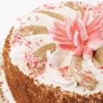 Decorate rectangular cake with fondant, piping gel, and edible flowers for a beautiful finish