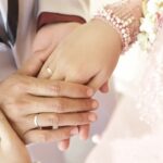 Do You Wear Your Engagement Ring on Your Wedding Day Photo of bride's hand with DO YOU WEAR YOUR ENGAGEMENT RING ON YOUR WEDDING DAY