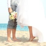 Photo of Mason at Kourtney and Travis wedding, smiling and standing with the newlyweds