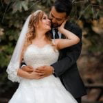 Smiling in a blue dress, hugging the bride